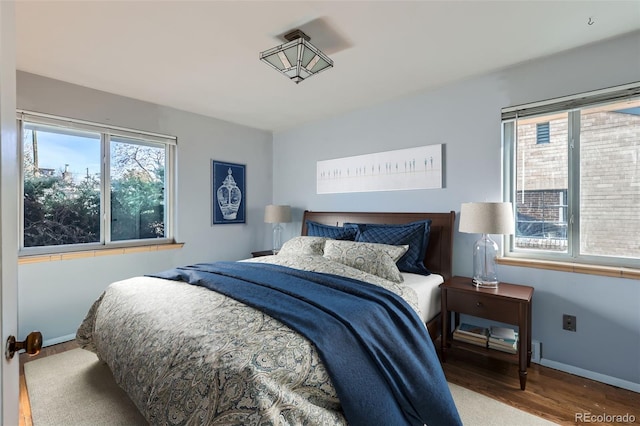 bedroom featuring baseboards and wood finished floors