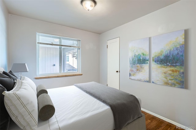 bedroom with dark wood-style flooring and baseboards