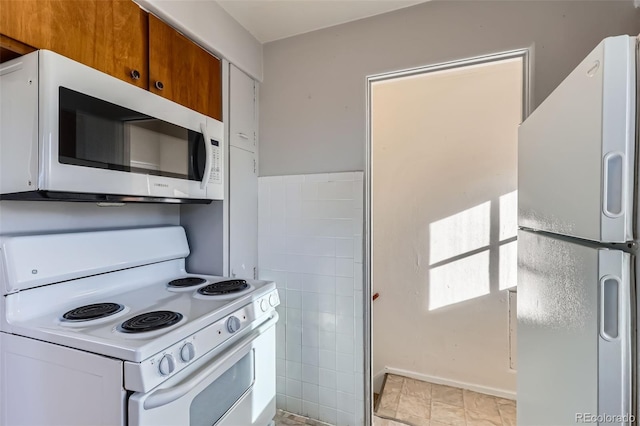 kitchen featuring white appliances, brown cabinetry, and tile walls