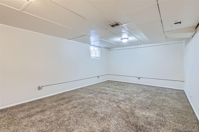 below grade area featuring baseboards, visible vents, and carpet flooring