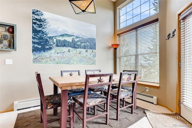 dining area featuring a baseboard heating unit and a healthy amount of sunlight
