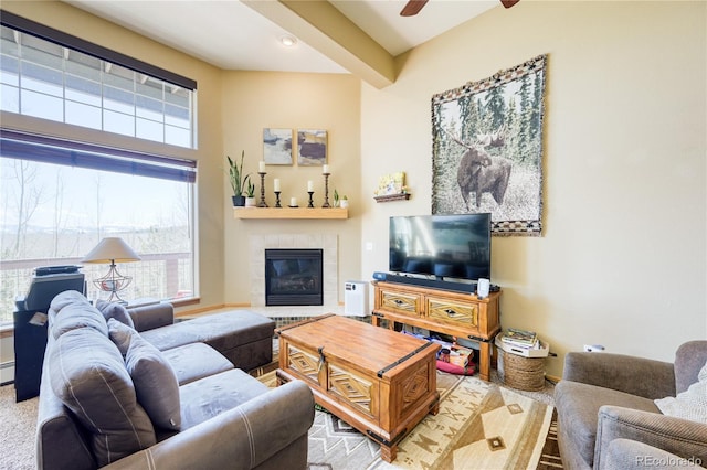 living room with a tiled fireplace and ceiling fan