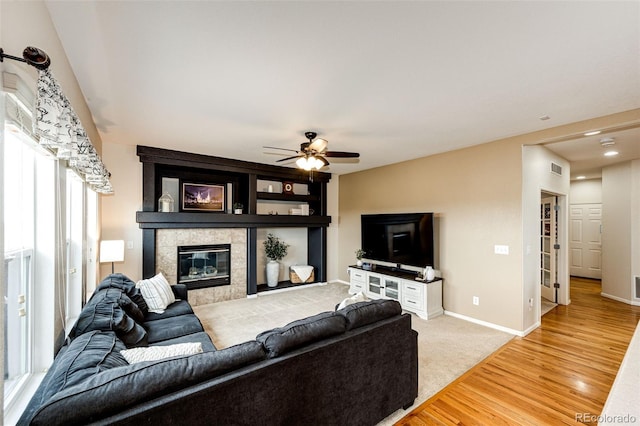 22962 Briar Leaf Ave, Parker, CO 80138 - living room featuring ceiling fan, light wood-style floors, a tile fireplace, and baseboards