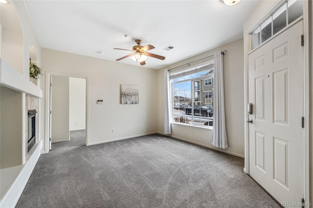 interior space featuring ceiling fan, carpet flooring, and a tile fireplace