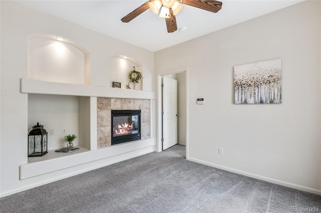 unfurnished living room featuring a fireplace, ceiling fan, and carpet