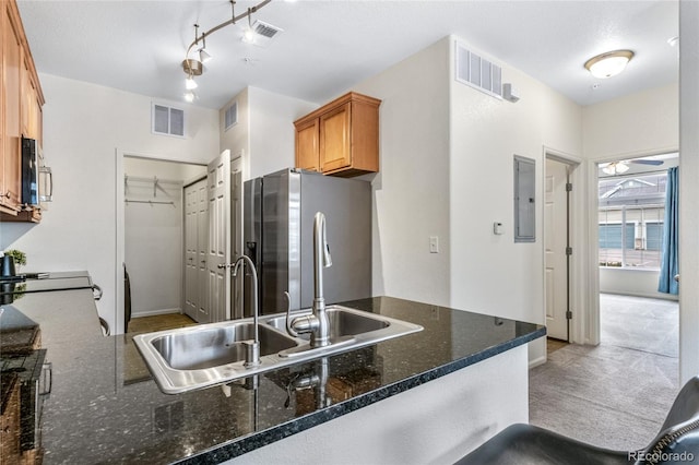 kitchen featuring sink, dark stone countertops, stainless steel appliances, electric panel, and kitchen peninsula