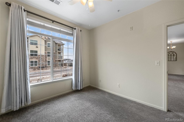 unfurnished room featuring plenty of natural light, ceiling fan with notable chandelier, and carpet