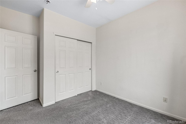 unfurnished bedroom featuring ceiling fan, a closet, and dark colored carpet