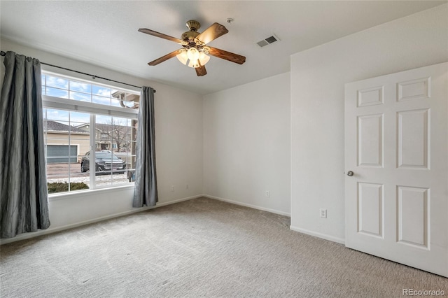 spare room with ceiling fan and light colored carpet