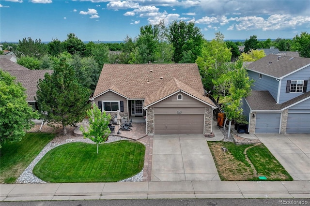 5402 S Queen Way, Littleton, CO 80127 - view of front of house featuring driveway, a garage, a front yard, and stone siding