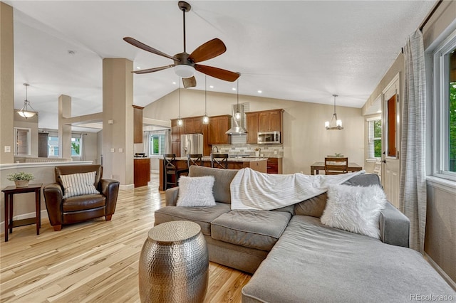 5402 S Queen Way, Littleton, CO 80127 - living area with vaulted ceiling, light wood-style floors, ceiling fan, and a chandelier