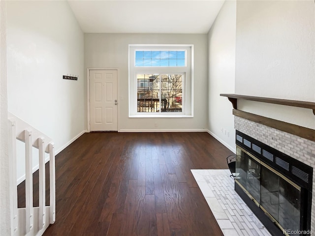 unfurnished living room with dark wood-type flooring