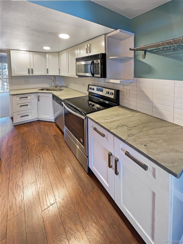 kitchen featuring appliances with stainless steel finishes, dark hardwood / wood-style floors, tasteful backsplash, sink, and white cabinets