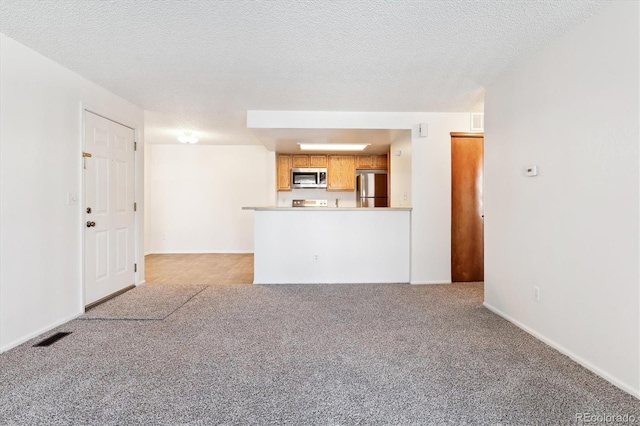 unfurnished living room featuring light carpet and a textured ceiling