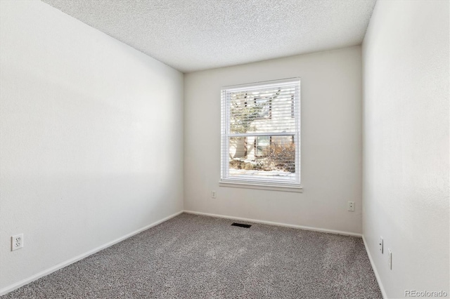 carpeted empty room featuring a textured ceiling