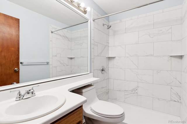 bathroom featuring a tile shower, vanity, and toilet