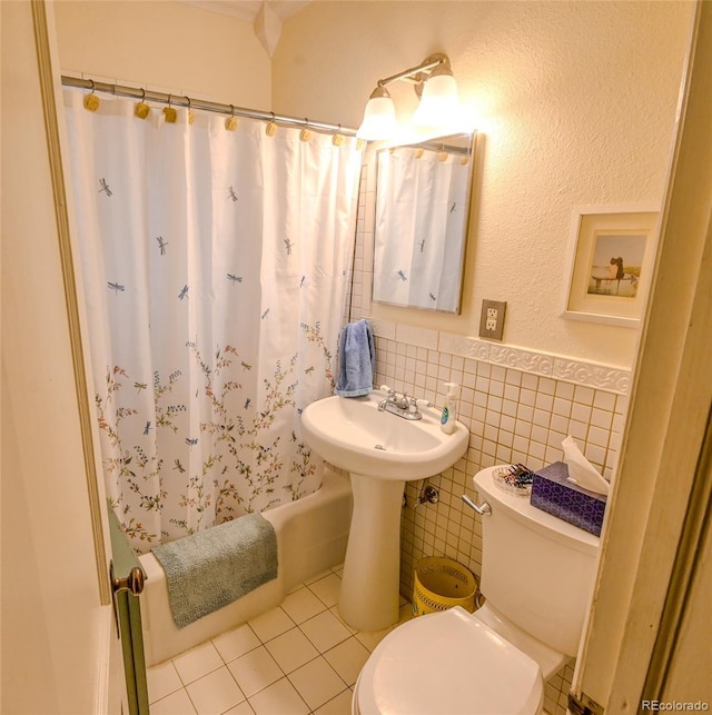 full bathroom featuring shower / tub combo with curtain, sink, tile walls, tile patterned flooring, and toilet