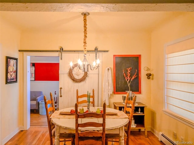 dining space with a barn door, wood-type flooring, a baseboard heating unit, and a notable chandelier