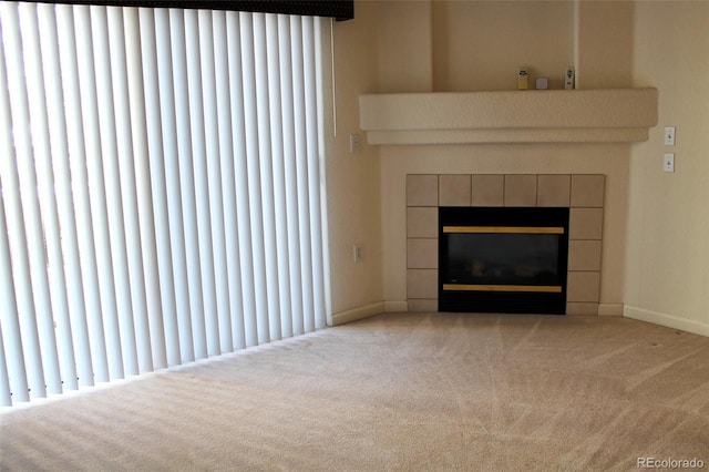 unfurnished living room featuring light carpet and a tiled fireplace