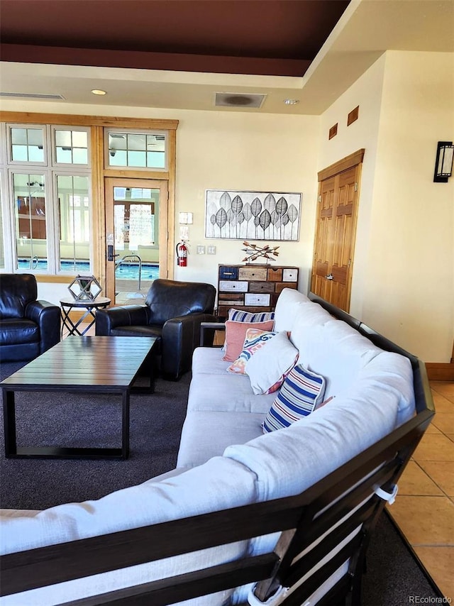 tiled living room featuring a tray ceiling