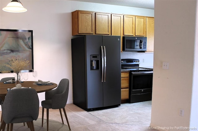 kitchen featuring black / electric stove, pendant lighting, and stainless steel fridge