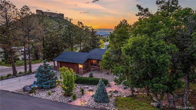19 Rock Ln, Castle Rock, CO 80104 - property exterior at dusk with an attached garage and roof with shingles