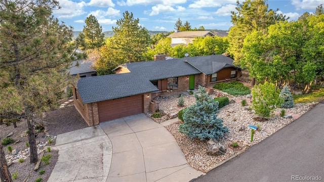 19 Rock Ln, Castle Rock, CO 80104 - view of front of house with brick siding, concrete driveway, a garage, roof with shingles, and a chimney