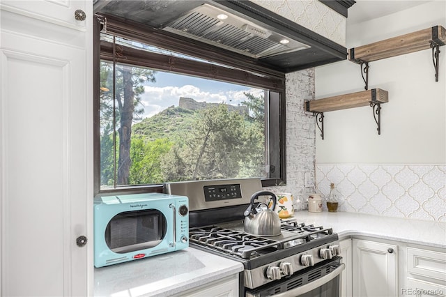 19 Rock Ln, Castle Rock, CO 80104 - kitchen featuring stainless steel range with gas cooktop, open shelves, white cabinetry, and custom range hood