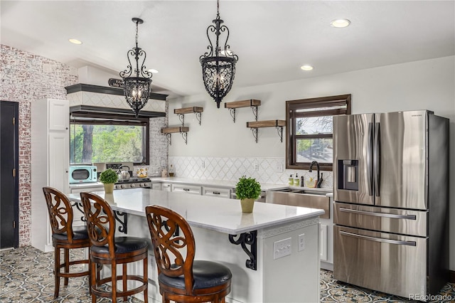 19 Rock Ln, Castle Rock, CO 80104 - kitchen with stainless steel appliances, light countertops, open shelves, white cabinetry, and a breakfast bar