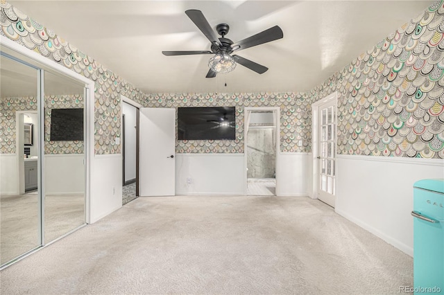 19 Rock Ln, Castle Rock, CO 80104 - unfurnished bedroom featuring wallpapered walls, carpet flooring, wainscoting, a ceiling fan, and connected bathroom