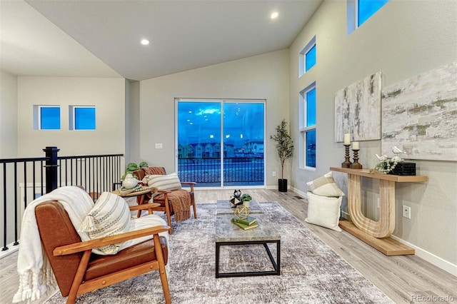 living room with baseboards, high vaulted ceiling, wood finished floors, and recessed lighting