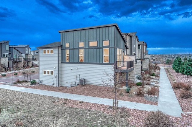 view of front of house featuring central AC unit, board and batten siding, and a residential view