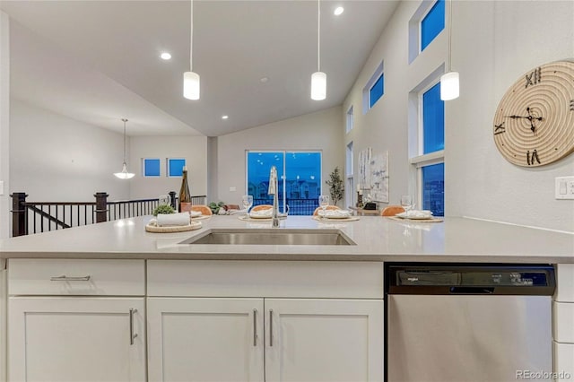 kitchen with light countertops, stainless steel dishwasher, a sink, and white cabinets