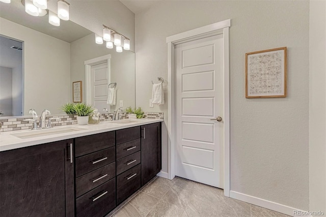 full bath featuring baseboards, double vanity, a sink, and decorative backsplash