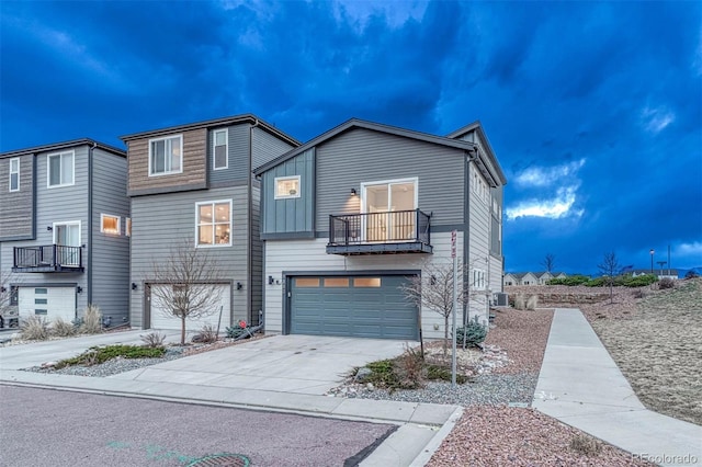 view of front of property featuring a garage, concrete driveway, and a balcony