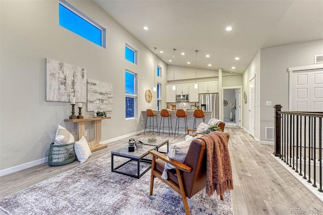 living room featuring high vaulted ceiling, recessed lighting, light wood-style flooring, and baseboards