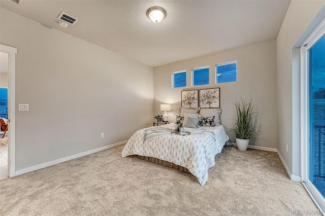 bedroom featuring visible vents, a textured ceiling, baseboards, and carpet flooring