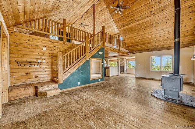 12524 Hilltop Pl, Kiowa, CO 80117 - unfurnished living room featuring a ceiling fan, high vaulted ceiling, a wood stove, wood-type flooring, and wooden ceiling