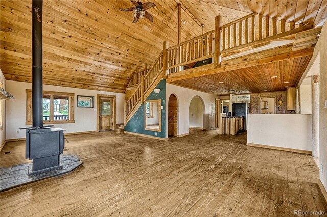 12524 Hilltop Pl, Kiowa, CO 80117 - unfurnished living room featuring high vaulted ceiling, a wood stove, stairway, wood-type flooring, and wooden ceiling