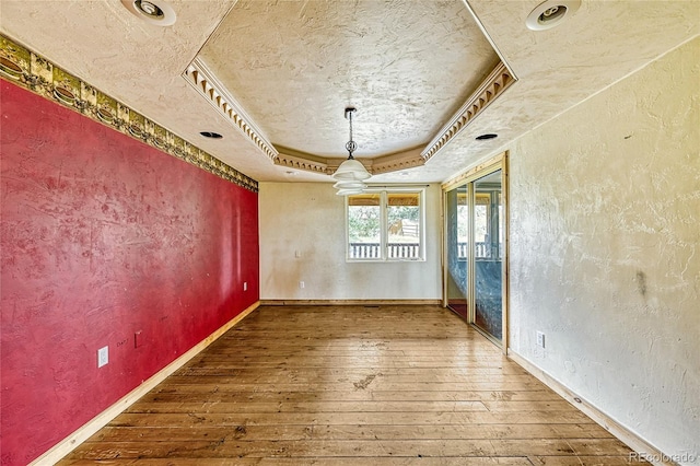 12524 Hilltop Pl, Kiowa, CO 80117 - unfurnished dining area with wood-type flooring, a raised ceiling, a textured wall, baseboards, and a textured ceiling