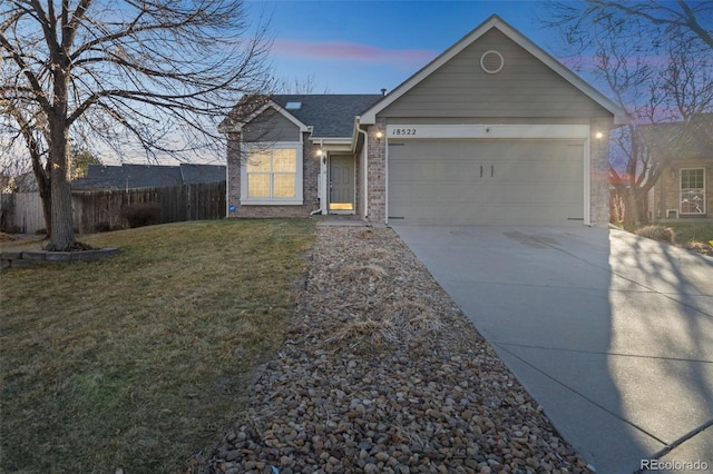 single story home featuring a yard and a garage