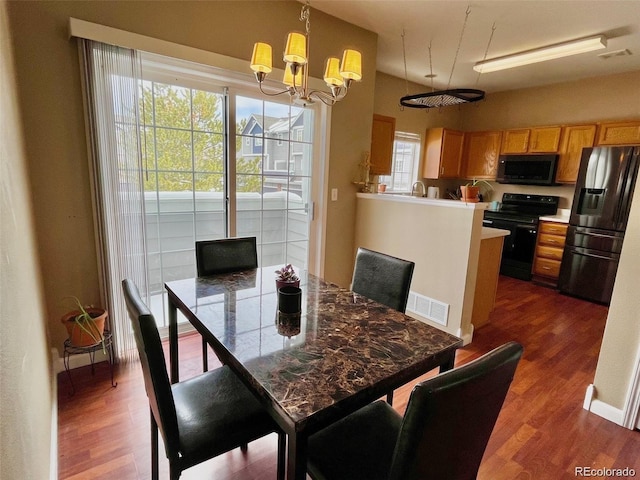 dining area with a notable chandelier, visible vents, and dark wood-style flooring