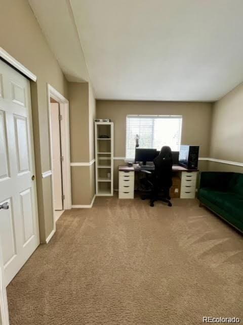 carpeted office featuring baseboards