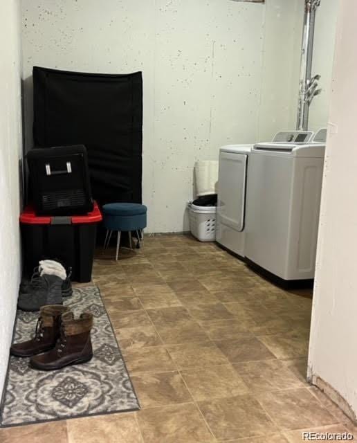 clothes washing area with washer and clothes dryer and laundry area