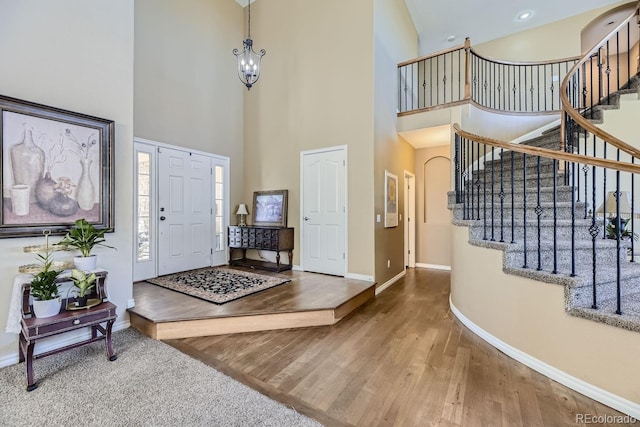 entryway featuring a chandelier, hardwood / wood-style floors, and a high ceiling