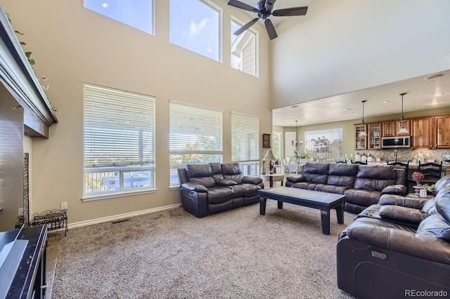 carpeted living room with a towering ceiling and ceiling fan