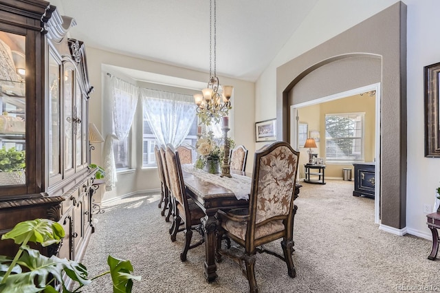 dining room featuring lofted ceiling, carpet flooring, and a notable chandelier