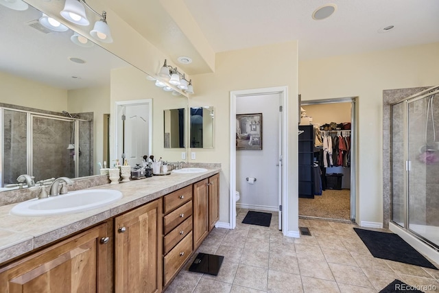 bathroom featuring vanity, a shower with shower door, and toilet