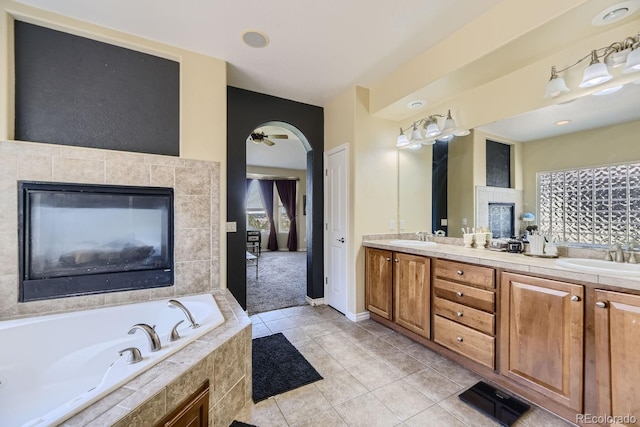 bathroom featuring vanity, tiled bath, tile patterned flooring, and ceiling fan