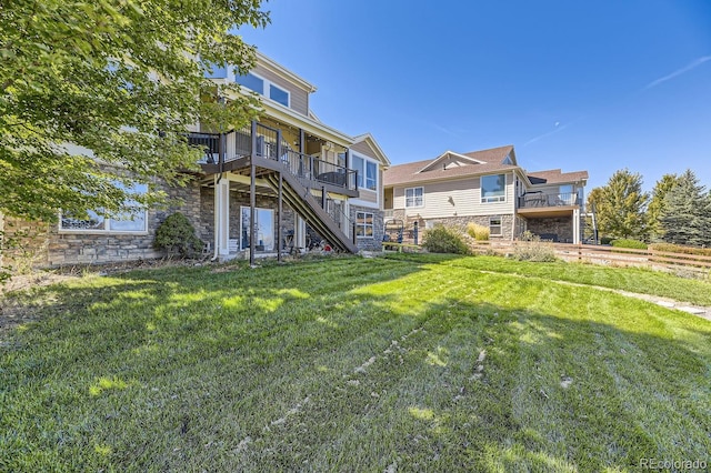 rear view of property featuring a deck and a lawn